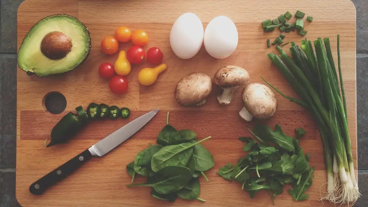 A imagem mostra uma tábua de cozinha com alguns ingredientes e temperos sobre ela e uma faca. Uma alusão aos ingredientes para compor uma landing page excelente.